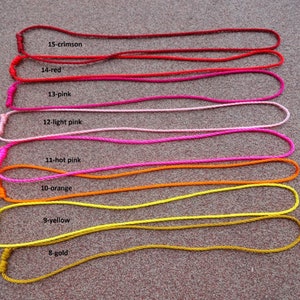 May include: Eight cords of different colors, from gold to crimson, are laid out in a row on a textured surface. Each cord is labeled with a number and color name, such as "8-gold" and "15-crimson".