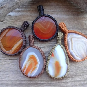 May include: Five agate stone pendants with different patterns and colors, each wrapped in macrame cord.