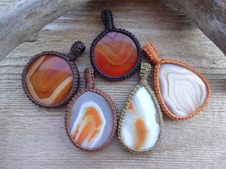 May include: Five agate stone pendants with different patterns and colors, each wrapped in macrame cord.