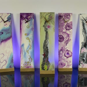 Puede incluir: Seis relojes de arte abstracto con diferentes esquemas de color. Cada reloj est&aacute; montado sobre una base de madera y tiene una esfera blanca con agujas negras.