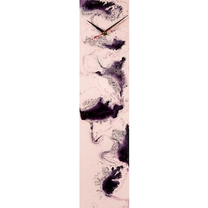 Pode incluir: Um relógio vertical longo com um mostrador branco e ponteiros pretos. O mostrador do relógio tem um fundo rosa com marmoreio abstrato roxo e preto.