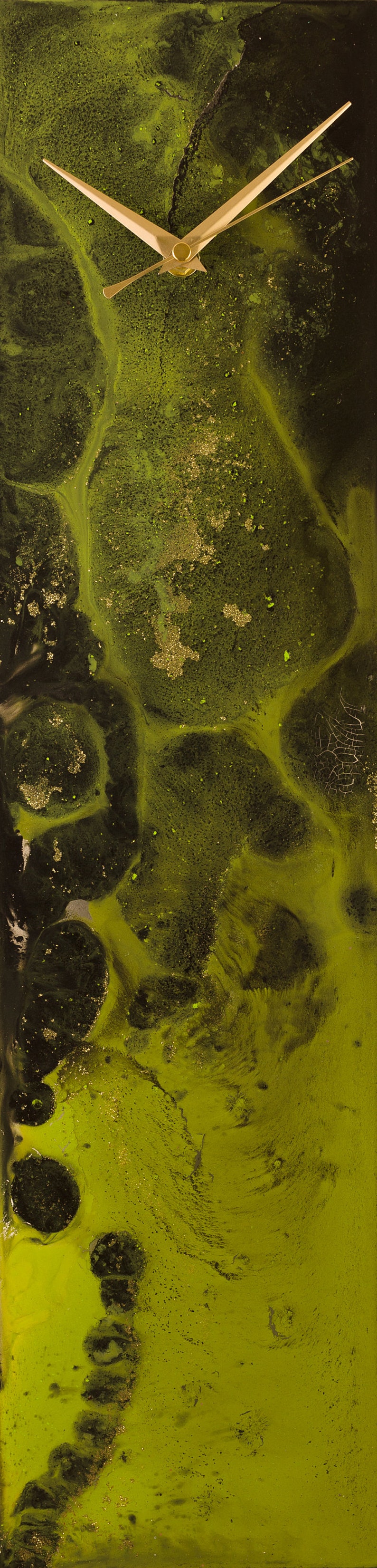 Op de afbeelding: Een klok met gouden wijzers tegen een abstracte groene en zwarte achtergrond. De achtergrond heeft een marmer effect met gouden vlekken.