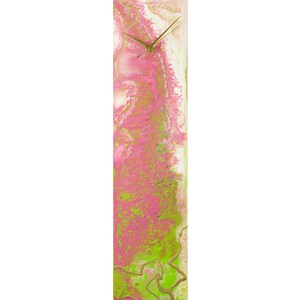 Pode incluir: Um relógio retangular alto com um mostrador branco e ponteiros dourados. O mostrador do relógio é coberto com um design abstrato rosa e verde.