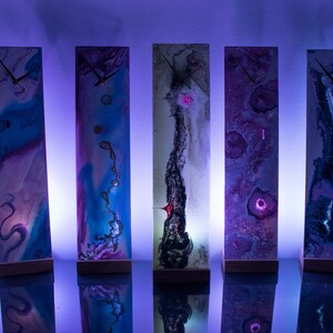 Puede incluir: Ocho relojes rectangulares y altos con dise&ntilde;os abstractos &uacute;nicos. Cada reloj tiene un fondo blanco con patrones coloridos y en espiral y una esfera de reloj dorada.