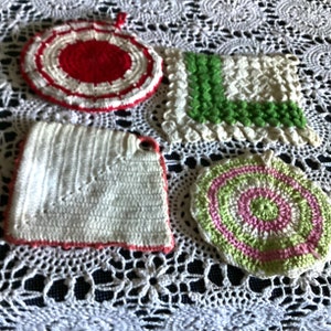 May include: Four crocheted pot holders in different colors and patterns. One is red and white with a circular design, another is green and white with a square design, another is white with a pink and green spiral design, and the last is white with a red border.