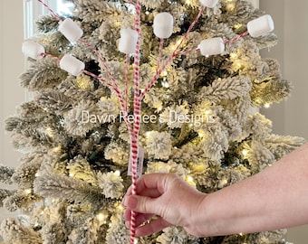 May include: A decorative floral pick featuring multiple white marshmallow-shaped ornaments attached to thin, flexible stems wrapped in red and white striped twine. The text Dawn Renee's Designs is visible in the center of the image.