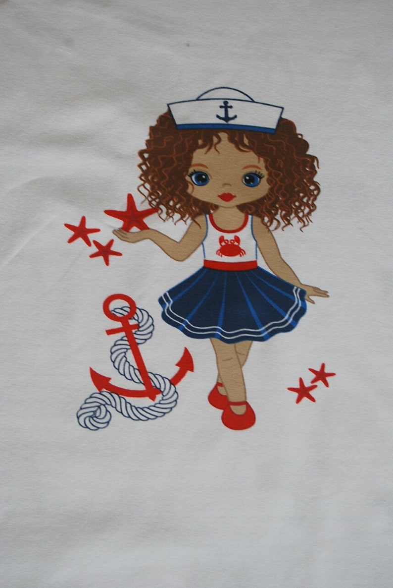 May include: A white t-shirt with a colorful illustration of a girl wearing a sailor hat and a blue and white dress. The girl is holding a red starfish and there is a red anchor with a white rope on the left side of the image. There are also red starfish scattered around the image.