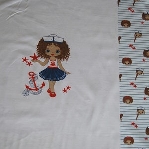 May include: White fabric with a red, white, and blue sailor girl illustration. The girl is holding a red star and there is an anchor with rope below her. The fabric has a repeating pattern of sailor girls with red stars on a white and blue striped background.