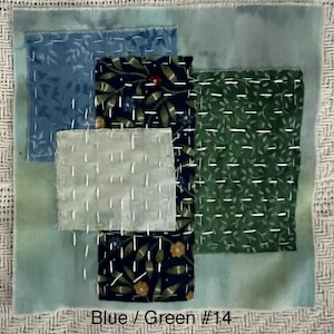 May include: A textile art piece with a patchwork design. It features squares of blue, green, and navy fabrics, each with unique patterns. White stitching accents the edges. The text "Blue / Green #14" is at the bottom.