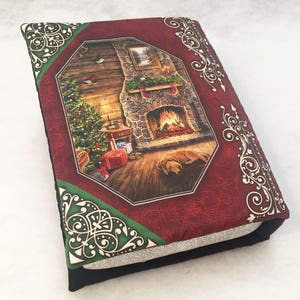 May include: A red book cover with a Christmas scene featuring a fireplace, a Christmas tree, and a dog. The cover has a gold and green decorative border.