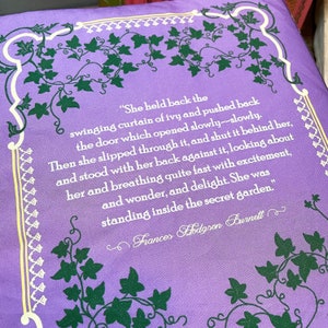 May include: A purple book cover with a quote from Frances Hodgson Burnett's "The Secret Garden." The quote reads, "She held back the swinging curtain of ivy and pushed back the door which opened slowly--slowly. Then she slipped through it, and shut it behind her, and stood with her back against it, looking about her and breathing quite fast with excitement, and wonder, and delight. She was standing inside the secret garden."