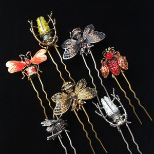 Puede incluir: Conjunto de siete horquillas de pelo doradas y plateadas con dise&ntilde;os de insectos. Los insectos est&aacute;n hechos de metal y decorados con diamantes de imitaci&oacute;n. Los dise&ntilde;os incluyen una abeja, una mariposa, un escarabajo y una lib&eacute;lula.