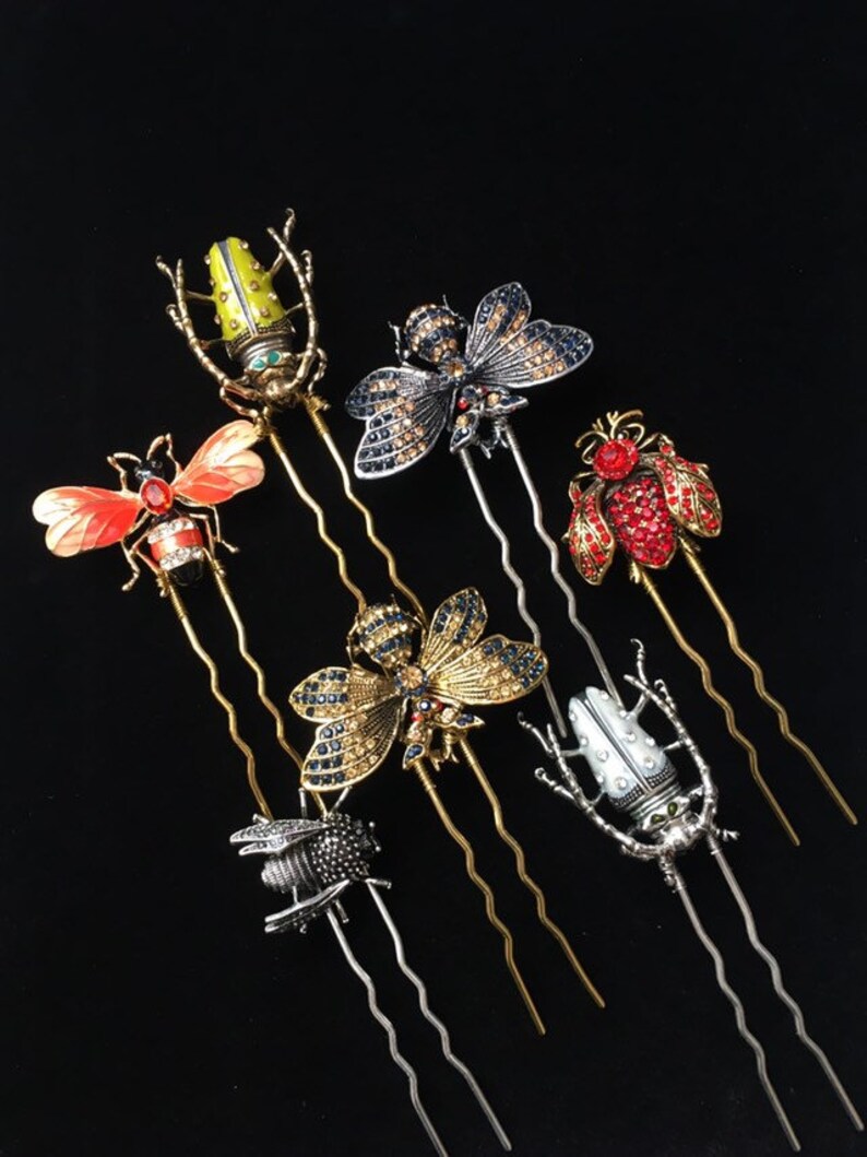 Puede incluir: Conjunto de siete horquillas de pelo doradas y plateadas con dise&ntilde;os de insectos. Los insectos est&aacute;n hechos de metal y decorados con diamantes de imitaci&oacute;n. Los dise&ntilde;os incluyen una abeja, una mariposa, un escarabajo y una lib&eacute;lula.