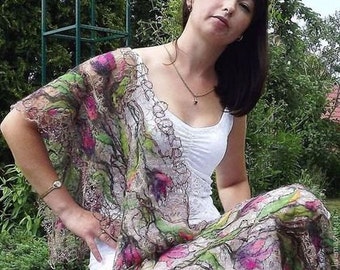 May include: A woman wearing a white tank top and a shawl with a floral design. The shawl is made of a lightweight fabric and has a delicate lace trim. The woman is sitting in a garden setting.