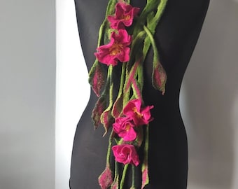 May include: A long green and pink felted scarf with pink flower accents. The scarf is displayed on a black mannequin.