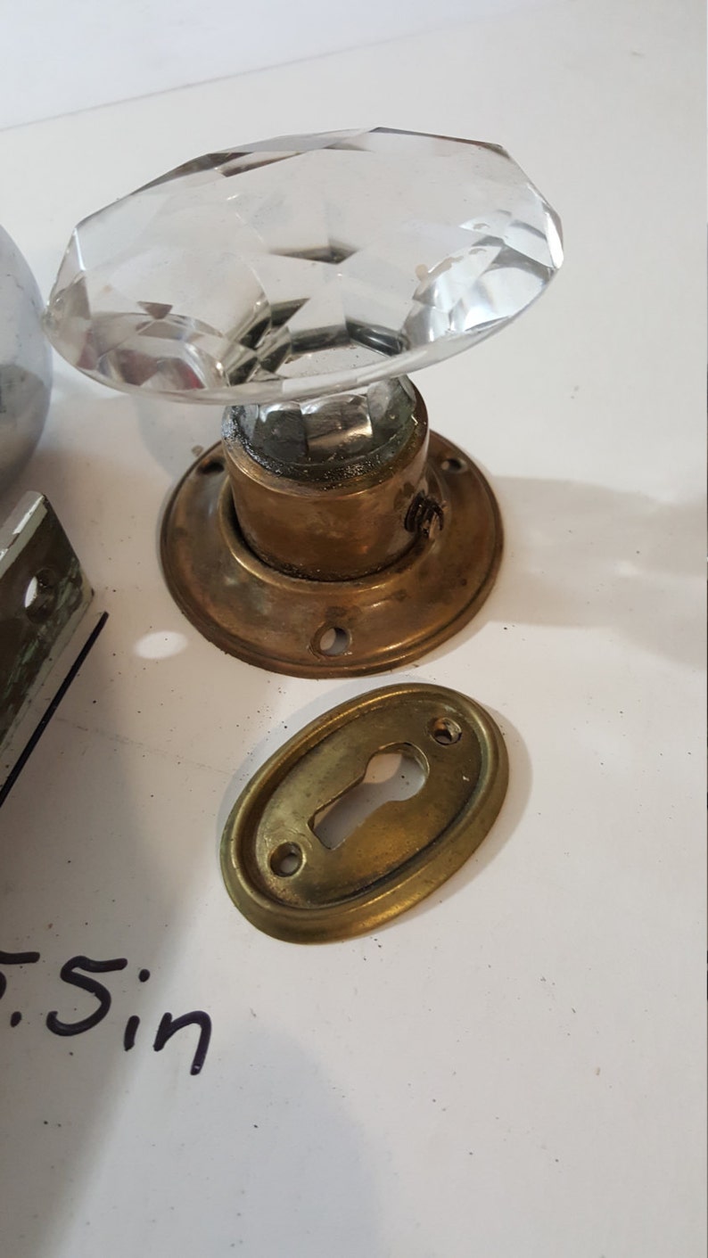 Salvaged crystal and chrome doorknobs with mortise and key hole covers.