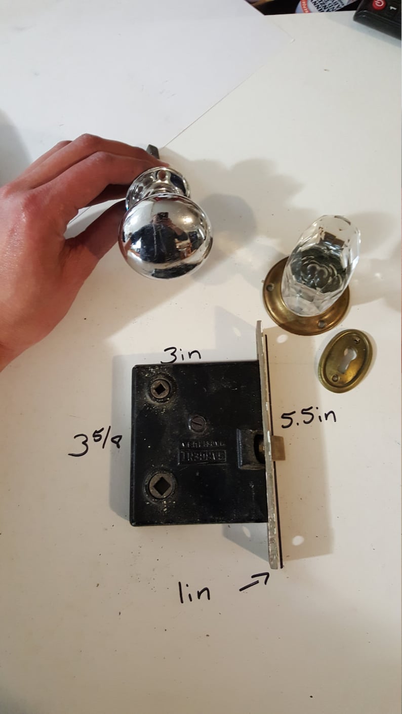 Salvaged crystal and chrome doorknobs with mortise and key hole covers.