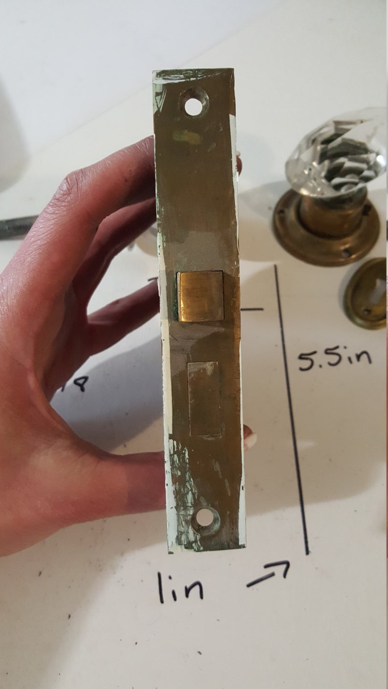 Salvaged crystal and chrome doorknobs with mortise and key hole covers.