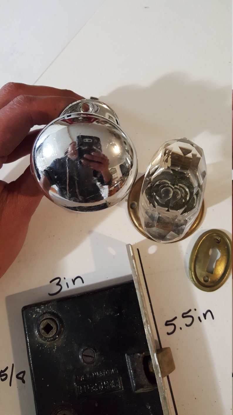 Salvaged crystal and chrome doorknobs with mortise and key hole covers.