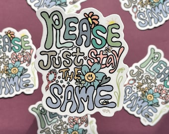 Puede incluir: Una pegatina con un diseño colorido y caprichoso que presenta el texto "Please Just Stay The Same". El texto está en una fuente retro y groovy con flores y estrellas que lo rodean.