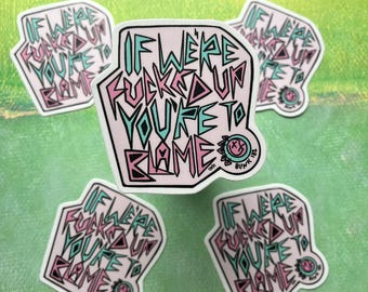 Puede incluir: Cinco pegatinas rosas y azules con el texto "If we're fucked up you're to blame" en una fuente estilizada y en negrita. Las pegatinas están sobre un fondo verde.