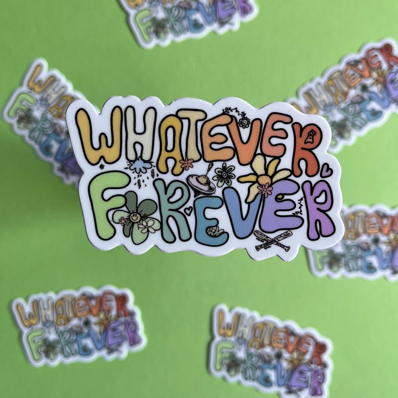 Puede incluir: Una pegatina blanca con el texto "Whatever Forever" en colores arco&iacute;ris. El texto est&aacute; rodeado de flores, corazones y otros peque&ntilde;os detalles.