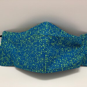 May include: A blue face mask with a pattern of green 1s and 0s, representing binary code.