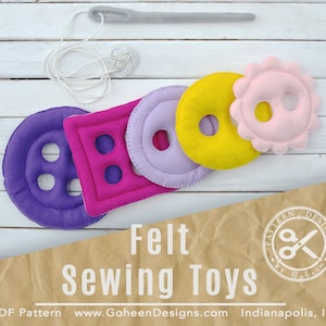 Puede incluir: Patrón de juguete de costura de fieltro con cinco formas de botones diferentes: un botón grande morado, un rectángulo rosa con tres agujeros, un círculo morado con un agujero, un círculo amarillo con un agujero y un botón rosa con forma de flor con un agujero. El patrón se llama "Felt Sewing Toys" de Gaheen Designs.