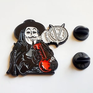 May include: Black and white enamel pin featuring a character from the movie V for Vendetta smoking a bong. The character is wearing a black cloak and a Guy Fawkes mask. The pin is attached to a black metal backing with a safety pin.
