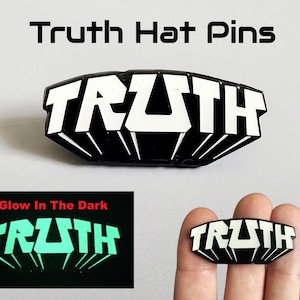 May include: A black and white enamel hat pin featuring the word TRUTH in a bold, stylised font. The design includes a glow-in-the-dark effect for the lettering. The pin is presented with text reading Truth Hat Pins and Glow In The Dark.
