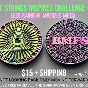 May include: Two round rainbow anodized metal challenge coins. The left coin features an eye within a triangle and the text NOT LOOKING BACK ONLY MOVING FORWARD. The right coin displays a flower of life pattern with the text BMFS and I'LL BE FREE FROM ALL THE SORROW I'VE BEEN DRINKING.