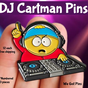 May include: A cartoon pin of a character with headphones and a DJ setup. The pin is yellow, red, and blue, with the text "DJ Cartman Pins". The pin is held in a hand. The pin is a collectable item.
