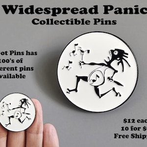 May include: Collectible pins featuring a black and white illustration of a musician playing instruments, with the text "Widespread Panic" and "Collectible Pins." The image also includes the text "We Got Pins has 100's of different pins available."