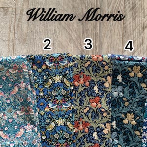 May include: Five fabric swatches with floral and bird patterns in various colors. The text "William Morris" is above the swatches. The fabrics feature designs with birds, flowers, and foliage in shades of blue, green, red, and cream.