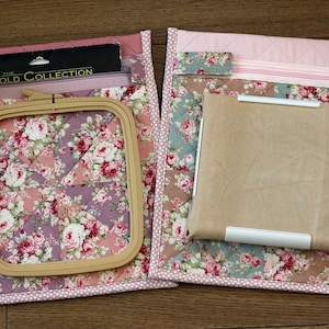 Puede incluir: Dos bolsas de proyecto de tela floral con un bastidor de bordado de madera y un paquete etiquetado como "The Gold Collection". Las bolsas presentan un diseño de patchwork con patrones florales rosas, morados y verdes, y un borde de lunares rosas.