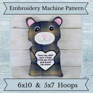 Puede incluir: Patrón de máquina de bordado para un oso de peluche que sostiene un parche en forma de corazón con el texto "Once my shirt now a bear, hold me close and know I'm there." El patrón está diseñado para aros de 6x10 y 5x7.
