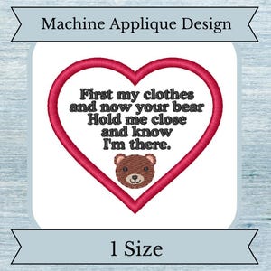 May include: Machine applique design featuring a red heart with the text "First my clothes and now your bear Hold me close and know I'm there." A brown teddy bear is inside the heart.