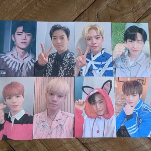 May include: Eight photo cards featuring different portraits of young men. The cards are white with a light pink or blue border. The men are wearing a variety of clothing, including a black and white patterned jacket, a blue and white striped shirt, a pink floral shirt, and a blue and white striped jacket.