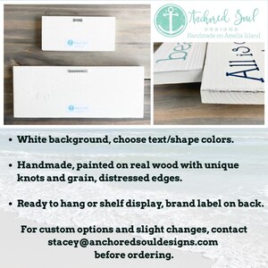 May include: Two rectangular white wooden signs with distressed edges and dark blue lettering. The back of each sign features a metal sawtooth hanger and a small blue and white brand label that reads Anchored Soul Designs Handmade on Amelia Island.