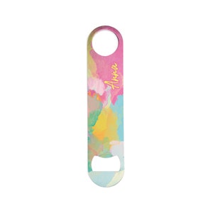 Könnte beinhalten: Ein farbenfroher Flaschenöffner mit einem lebendigen abstrakten Design in Rosa, Gelb, Blau und Grün. Das Wort "Anna" ist in gelber Schrift geschrieben. Der Öffner hat ein Loch zum Aufhängen und einen Flaschenöffner.