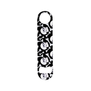 May include: A black metal bottle opener with a skull and crossbones pattern.