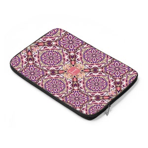 May include: A laptop sleeve with a colorful mandala pattern in shades of pink, purple, and gold. The sleeve has a zipper closure and a monogrammed initial "L" in the center.