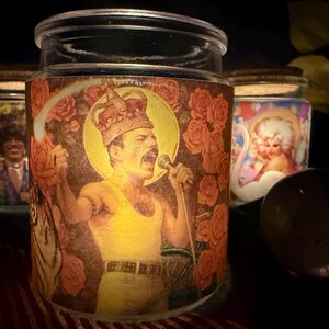 May include: Glass jars with printed images of famous figures. The main jar features a vintage image of a singer wearing a crown and holding a microphone, surrounded by roses. Other jars have similar vintage images.