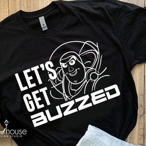 May include: Black t-shirt with a white outline of Buzz Lightyear from Toy Story. The text "Let's Get Buzzed" is printed in white below the image.