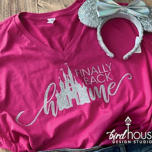 May include: Pink t-shirt with a silver glitter design of a castle and the text "Finally Back Home".