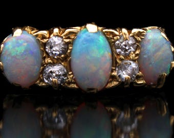 Anillo antiguo victoriano de ópalo y diamantes: oro amarillo de 18 quilates, engaste con volutas.