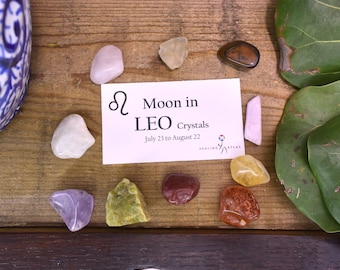 May include: A set of crystals for the Moon in Leo zodiac sign. The crystals are arranged in a circle around a card that reads "Moon in LEO Crystals July 23 to August 22".