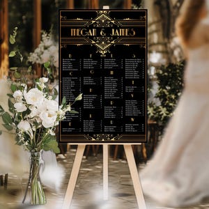 Peut inclure: Un tableau de mariage noir et or avec les noms "Megan & James" en haut. Le tableau est sur un chevalet en bois et liste les noms des invités de mariage par table.