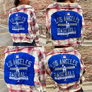 May include: A cropped plaid flannel shirt with a blue patch on the back that says "Los Angeles Baseball MLB Authentic Collection" with a baseball logo and the LA logo.