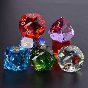 Peut inclure: Un ensemble de dés à facettes multiples aux couleurs variées, dont le rouge, le violet, le vert, le bleu et le transparent. Chaque dé comporte des chiffres dorés, parfaits pour les jeux de société. Les dés sont disposés sur une surface sombre.